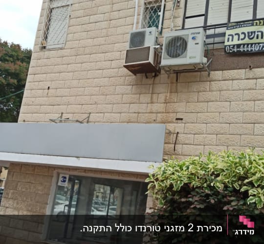 שני מזגנים מותקנים על קיר חיצוני של בניין